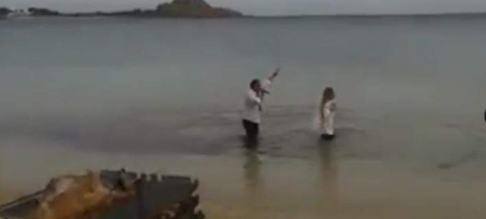 Τραγουδιστής με το μικρόφωνο στο χέρι βουτά στα παγωμένα νερά της Μυκόνου μαζί με τουρίστρια - ΒΙΝΤΕΟ